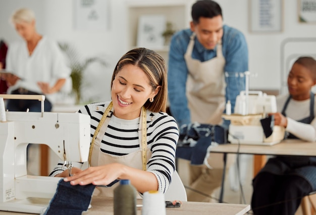 Szczęśliwa i uśmiechnięta szwaczka pracująca przy projektowaniu w fabryce włókienniczej i szyciu tkanin Radosna projektantka i krawcowa przy pracy przy naprawie ubrań w warsztacie