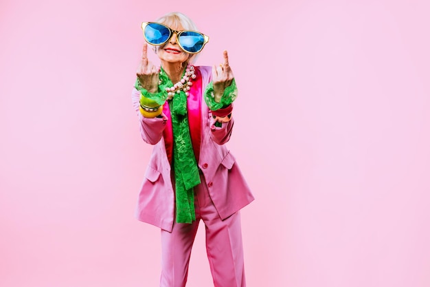Szczęśliwa i zabawna fajna starsza pani z portretem modnych ubrań na kolorowym tle Młoda babcia z ekstrawaganckimi koncepcjami stylu dotyczącymi stażu życia i osób starszych