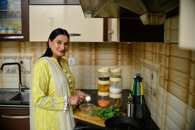 szczęśliwa kobieta gotuje w swojej kuchni indyjska modelka pakistańska
