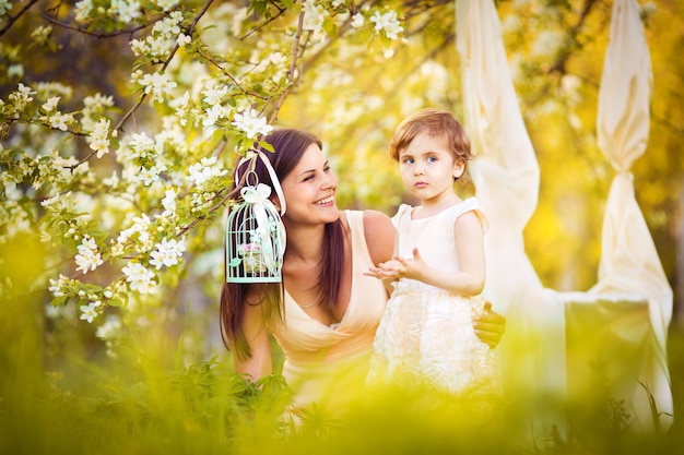 Szczęśliwa kobieta i dziecko w ogrodzie kwitnącej wiosny. Dziecko całuje kobietę. Koncepcja wakacje dzień matki