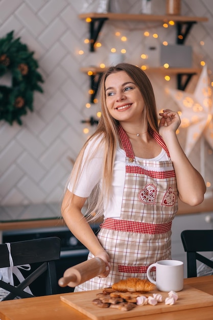 Szczęśliwa kobieta przygotowuje świąteczne ciasteczka w domu wesoła dama w fartuchu