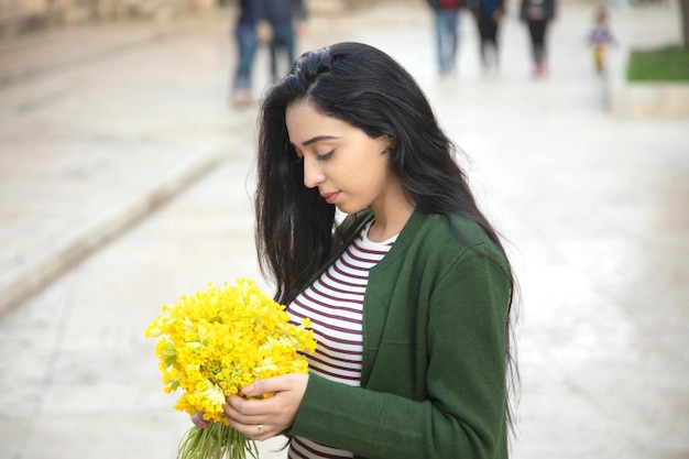 Szczęśliwa kobieta ręcznie żółte kwiaty