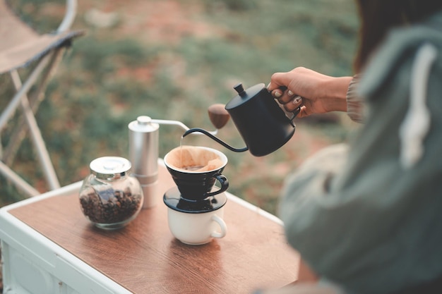 Zdjęcie szczęśliwa kobieta relaksuje się w wakacyjny poranek podróżując i spoczynku w stylu slow life camping selektywna i miękka ostrość