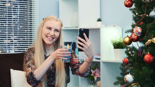 Szczęśliwa kobieta robi rozmowę wideo przez smartphone