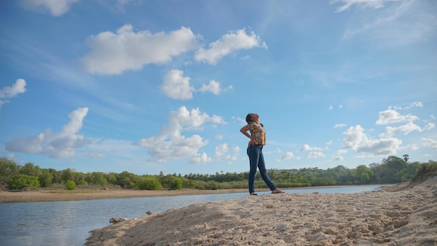 Szczęśliwa kobieta skacze ciesząc się pięknem plaży