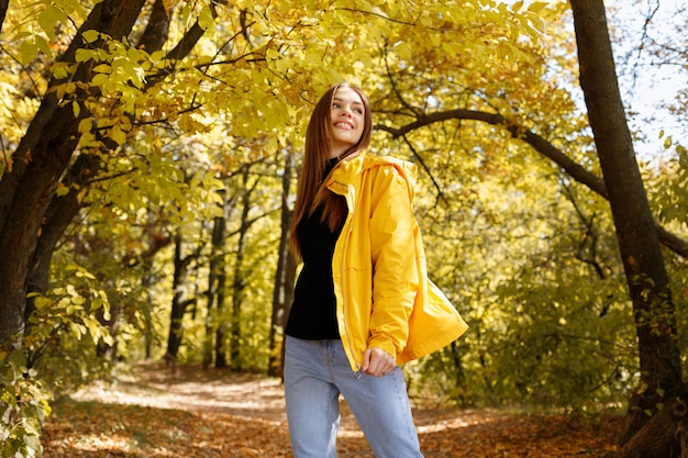 Szczęśliwa Kobieta śmiejąca Się W żółtych Ubraniach Przed Jesiennymi żółtymi Liśćmi. Uśmiechnij Się Jesień