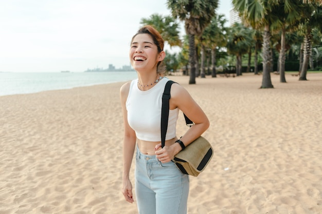 Szczęśliwa kobieta śmieje się i spaceruje po plaży