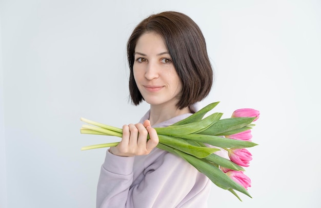 Szczęśliwa kobieta trzyma bukiet kwiatów tulipanów Odosobniony portret kobiety