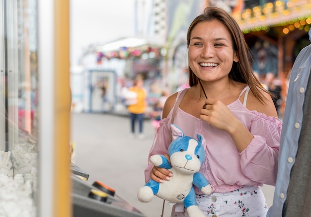 Zdjęcie szczęśliwa kobieta trzyma zabawkę z gry w parku rozrywki