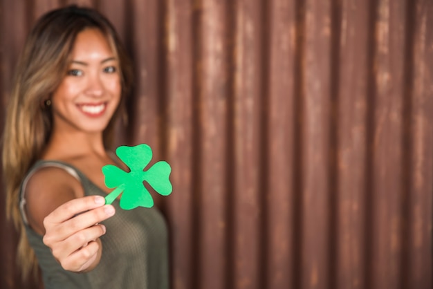 Zdjęcie szczęśliwa kobieta trzyma zielonego papieru koniczynę
