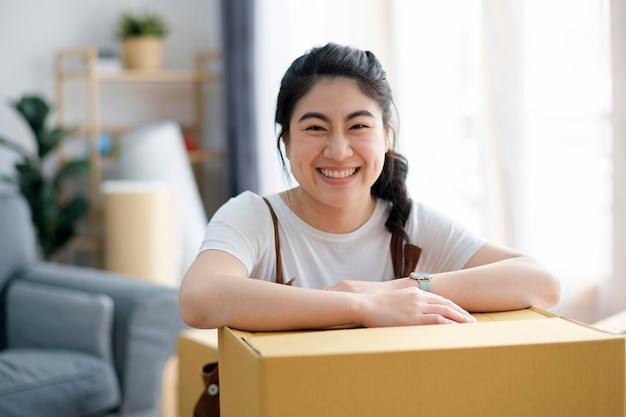 Zdjęcie szczęśliwa kobieta uśmiecha się w domu podczas przeprowadzki z pudełkami