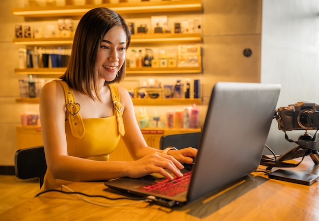 Szczęśliwa kobieta używa laptop w kawiarni