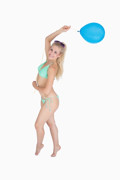 Szczęśliwa kobieta w bikini mienia balonie