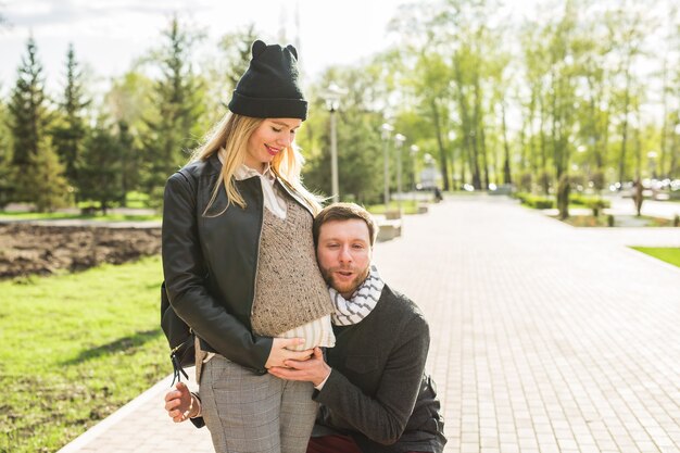 Zdjęcie szczęśliwa kobieta w ciąży i jej mąż w parku.