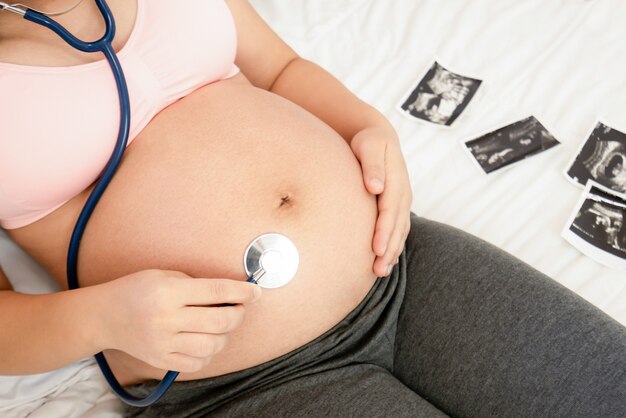 Szczęśliwa kobieta w ciąży z dzieckiem w brzuchu w ciąży. Opieka prenatalna położnicza i ciąża kobieca.