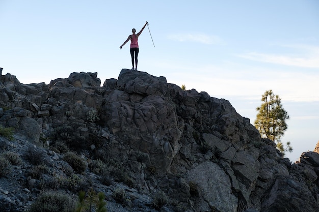 Szczęśliwa kobieta wędrująca po szczycie góry