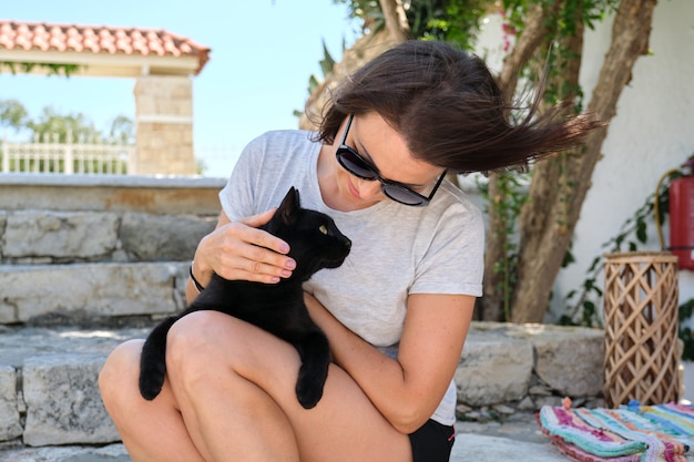 Szczęśliwa kobieta z czarnym kotem, odkryty portret właściciela i zwierzaka.