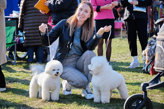 Szczęśliwa kobieta z dwoma ukochanymi psami rasy Bichon Frise