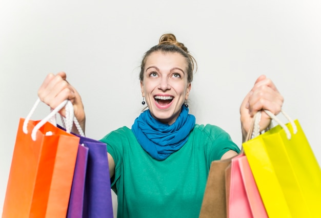 Szczęśliwa kobieta z torba na zakupy cieszy się w zakupy.