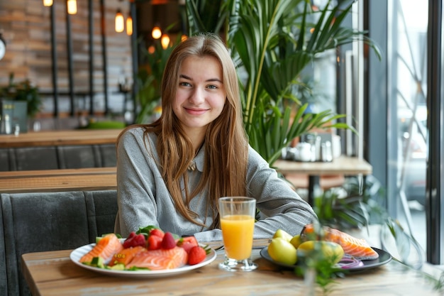 Zdjęcie szczęśliwa kobieta z zdrowym posiłkiem w nowoczesnej kawiarni