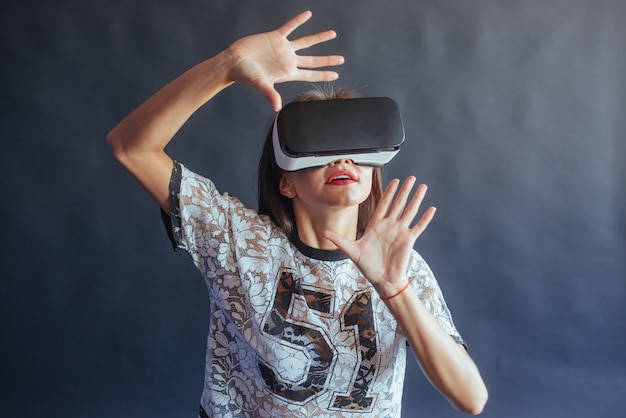 Szczęśliwa kobieta zyskuje doświadczenie w korzystaniu z zestawu wirtualnej rzeczywistości w okularach VR.