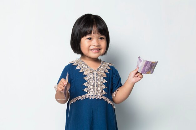 Szczęśliwa Mała Azjatycka Dziewczyna Trzyma Pieniądze Na Białym Tle