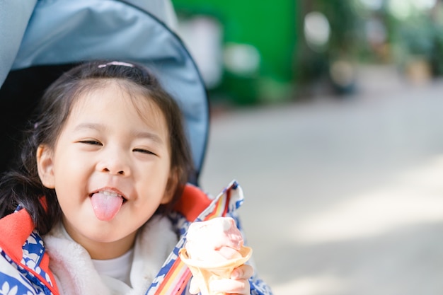 Zdjęcie szczęśliwa mała azjatykcia dziewczyna je miękką śmietankę lub lody. hokkaido japonia.