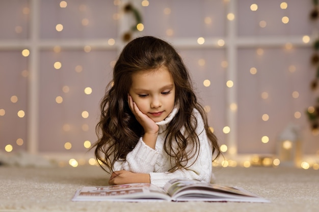 Szczęśliwa mała dziewczynka czyta bajkę