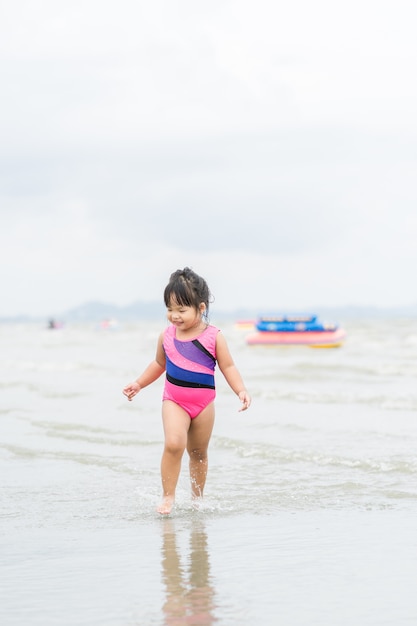 szczęśliwa mała dziewczynka działa na plaży