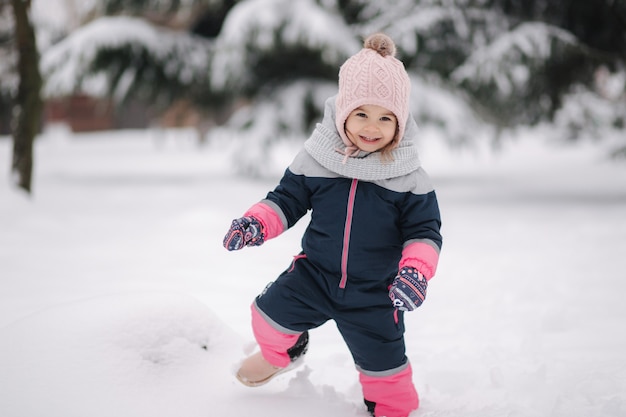 Szczęśliwa mała dziewczynka spaceru w parku na śniegu