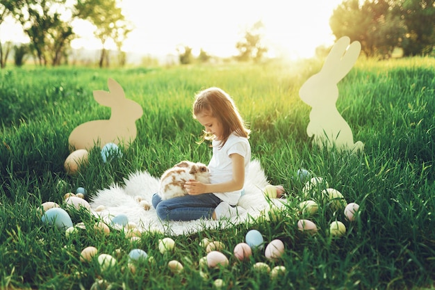 Szczęśliwa mała dziewczynka trzyma ślicznego puszystego królika