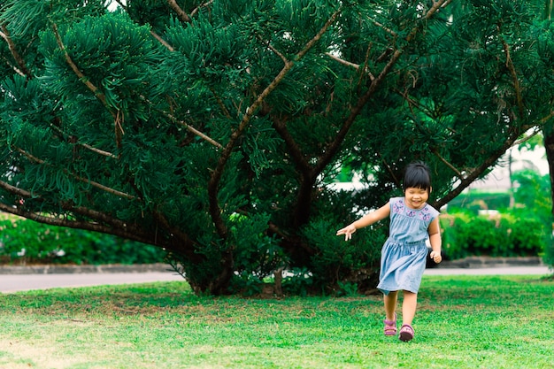 Szczęśliwa mała dziewczynka w smokingowym bieg w parku