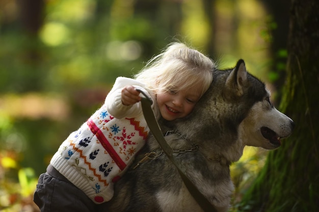 Szczęśliwa mała dziewczynka z psem husky