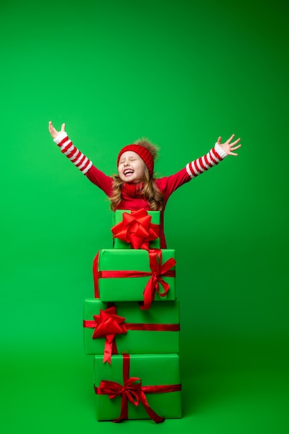 Szczęśliwa mała dziewczynka ze stosem pudełek na prezenty świąteczne