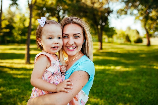 Szczęśliwa mama i córka ono uśmiecha się przy naturą.