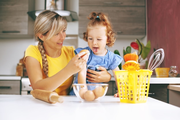 Zdjęcie szczęśliwa mama i jej córeczka gotowanie w kuchni