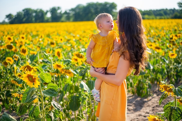 Szczęśliwa mama i jej córeczka na polu słoneczników