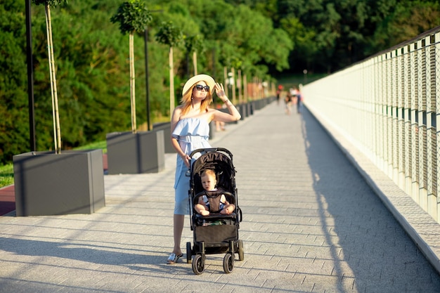 Szczęśliwa Mama Z Dzieckiem W Wózku Spaceruje Latem Po Parku