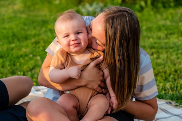 Szczęśliwa mama z małym synem na kocu przy latem