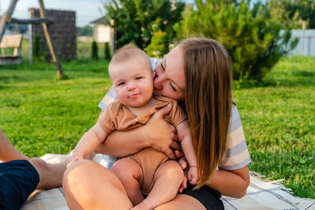 Szczęśliwa mama z małym synem na kocu przy latem