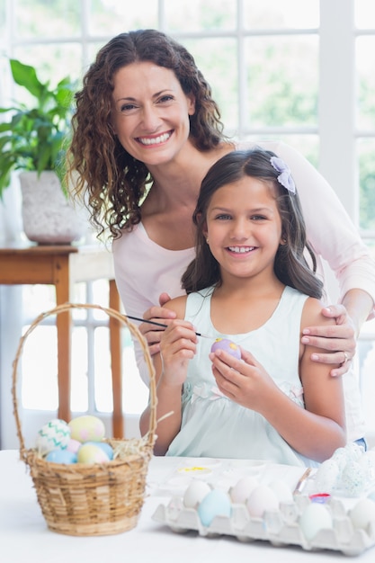 Szczęśliwa matka i córka maluje Easter jajka