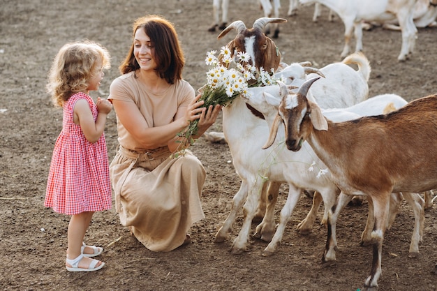 Szczęśliwa Matka I Jej Córka Karmią Kozy Na Ekologicznej Farmie.