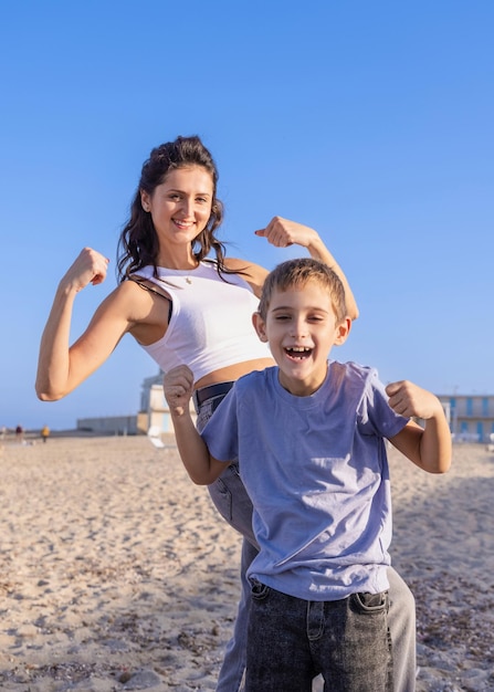 Szczęśliwa matka i syn Wyświetlono silne ramiona na plaży w słoneczny dzień o zachodzie słońca Rodzina razem