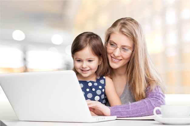 Szczęśliwa matka z córką korzystająca z laptopa w domu