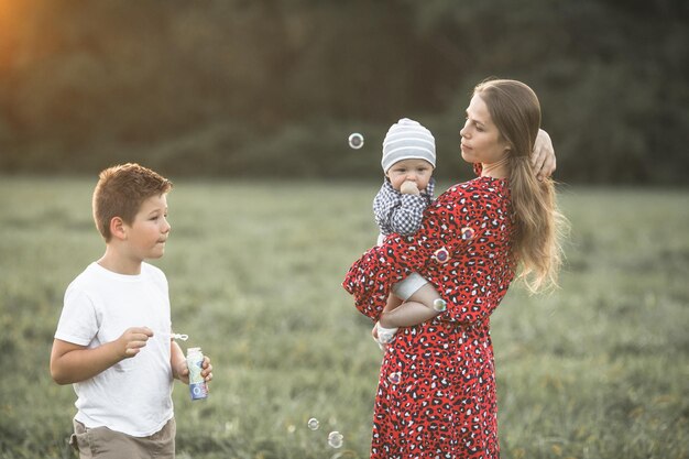 Szczęśliwa matka z synem cieszącym się przyrodą w słoneczny dzień Ujęcie pięknej młodej mamy bawiącej się i przytulającej swojego uroczego synka