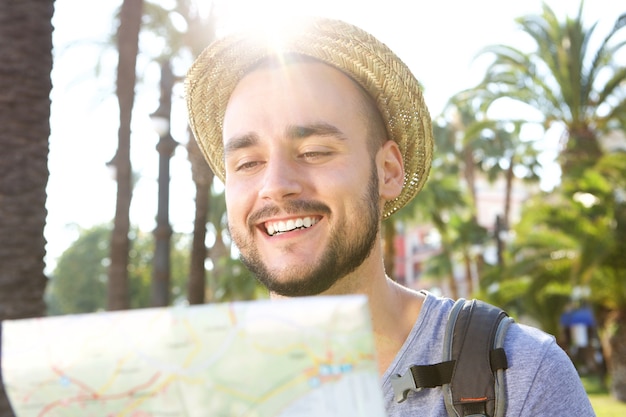 Szczęśliwa mężczyzna czytania mapa podczas gdy na wakacje