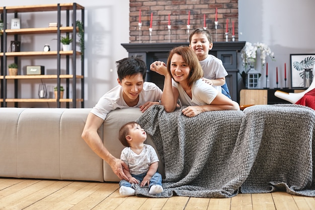 Szczęśliwa Międzynarodowa Koncepcja Rodziny. Tata, Mama, Syn I Córeczka Pozuje Do Kamery W Domu, Zajmują Się Rodzicielstwem W Domu. Wakacje W Domu, Rodzicielstwo, Dzieci Koncepcyjne I Rodzice.