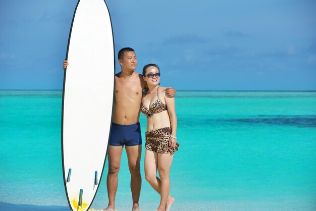 szczęśliwa młoda azjatycka para bawi się i spędza romantyczny czas latem na pięknej białej piaszczystej plaży