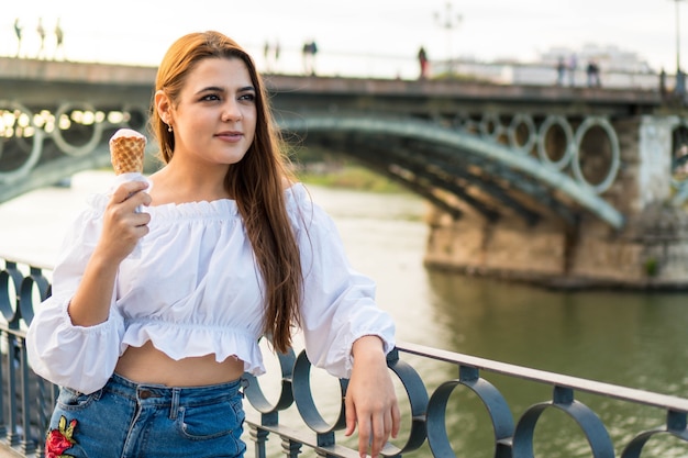 Zdjęcie szczęśliwa młoda dziewczyna je loda latem w hiszpanii dziewczyna na wakacjach w sewilli