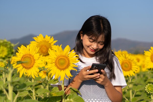 Szczęśliwa młoda dziewczyna selfie z pięknym słonecznikiem i niebieskim niebem